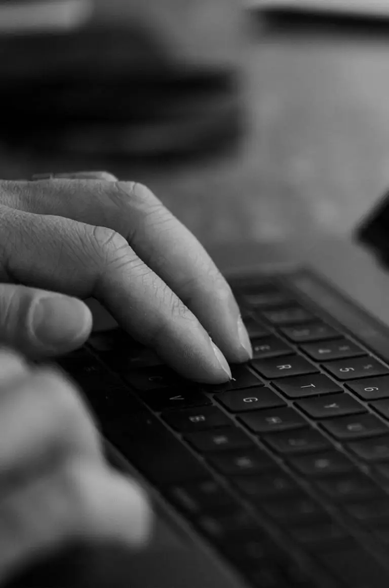 Hands typing on a laptop