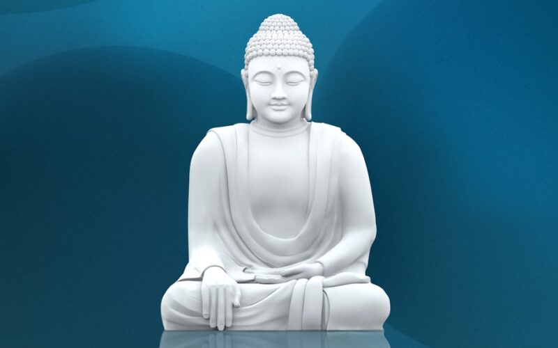 A white buddha statue sitting on top of a table