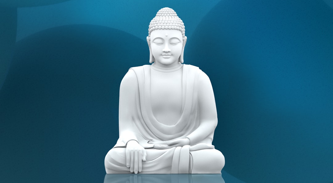 A white buddha statue sitting on top of a table