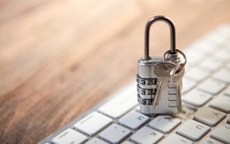 Padlock and keys resting on a computer keyboard.